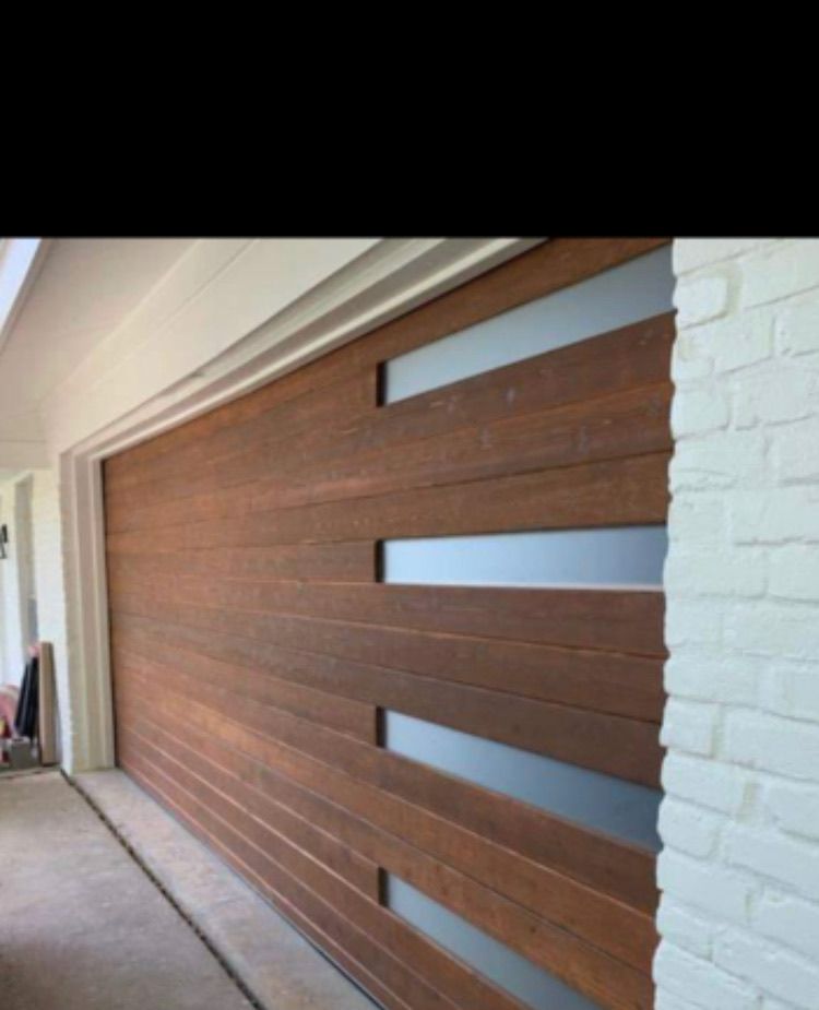 Wooden garage door with frosted glass windows. White brick wall to the right.