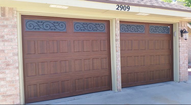 Two brown garage doors with decorative black scrollwork, brick exterior, address 2909.