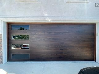 Wooden garage door with four rectangular windows.
