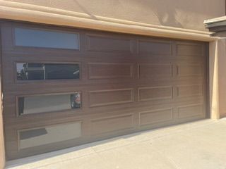 Brown garage door with three horizontal glass panels; front view.