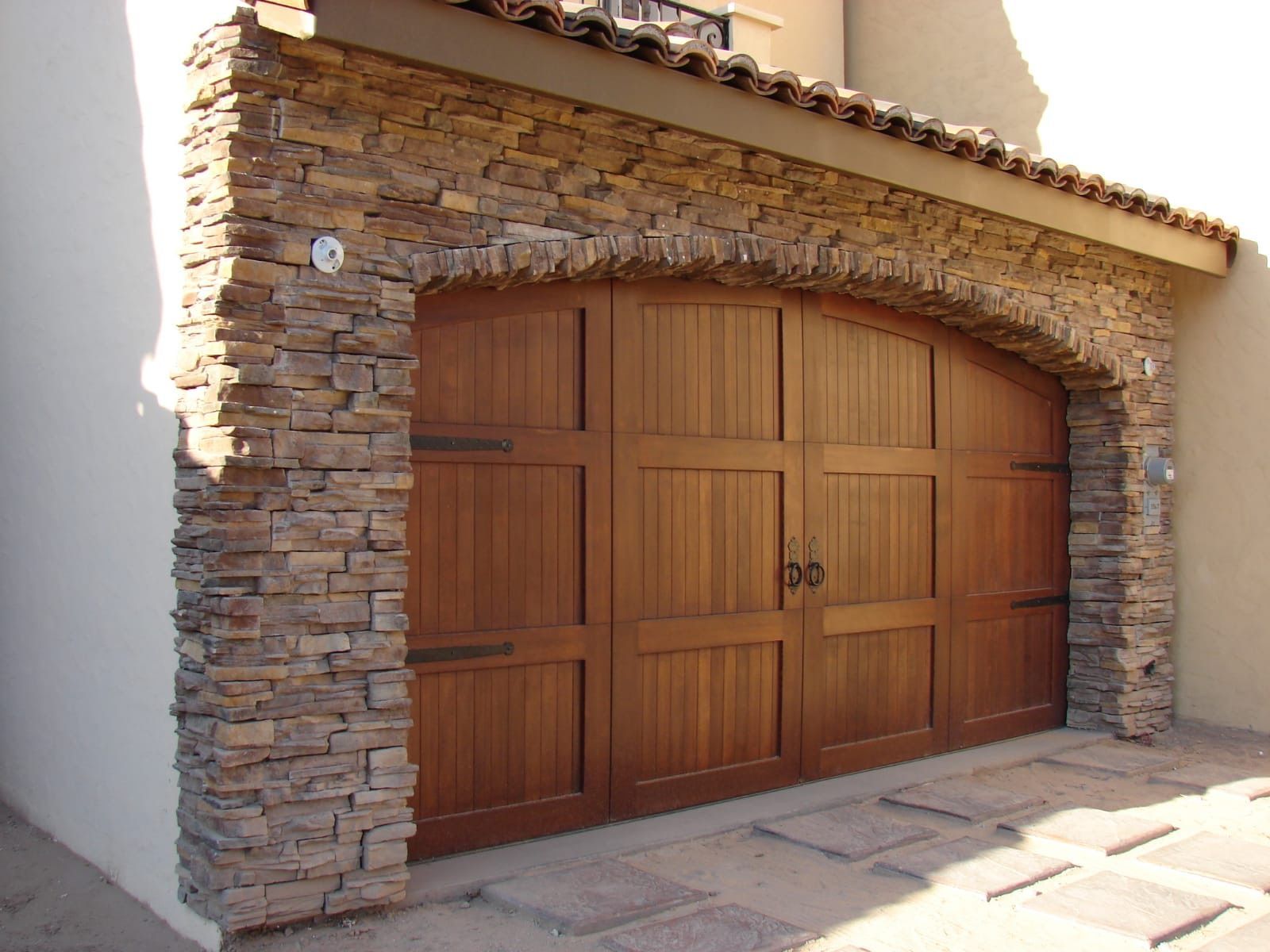 Wooden garage door with stone archway.