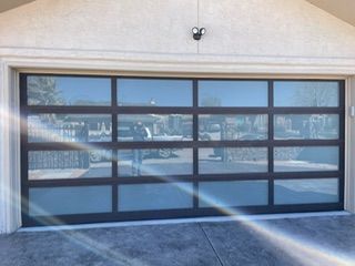 Garage door with tinted glass panels in a brown frame.