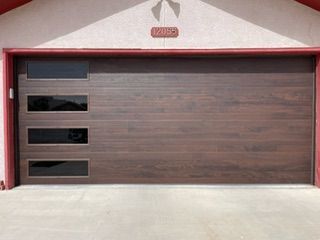 Brown garage door with three horizontal glass panels, red trim, and address number above.