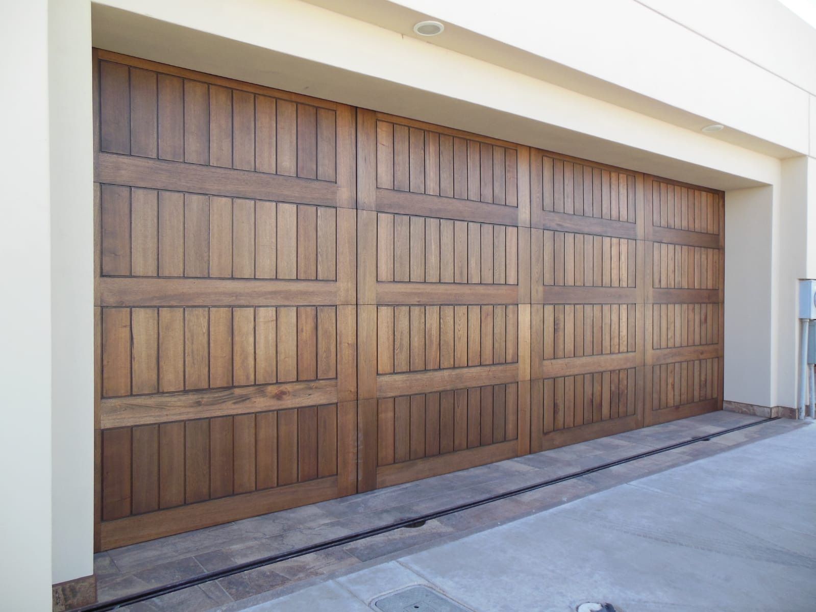 Wooden garage door with vertical planks and horizontal crossbeams.