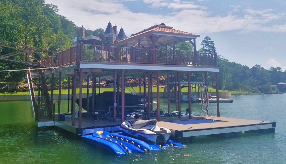 Double slip sundeck boat dock with burnished slate posts and railing matched with our copper metallic roof panels - Dock Solutions of Kentucky | Lexington, KY