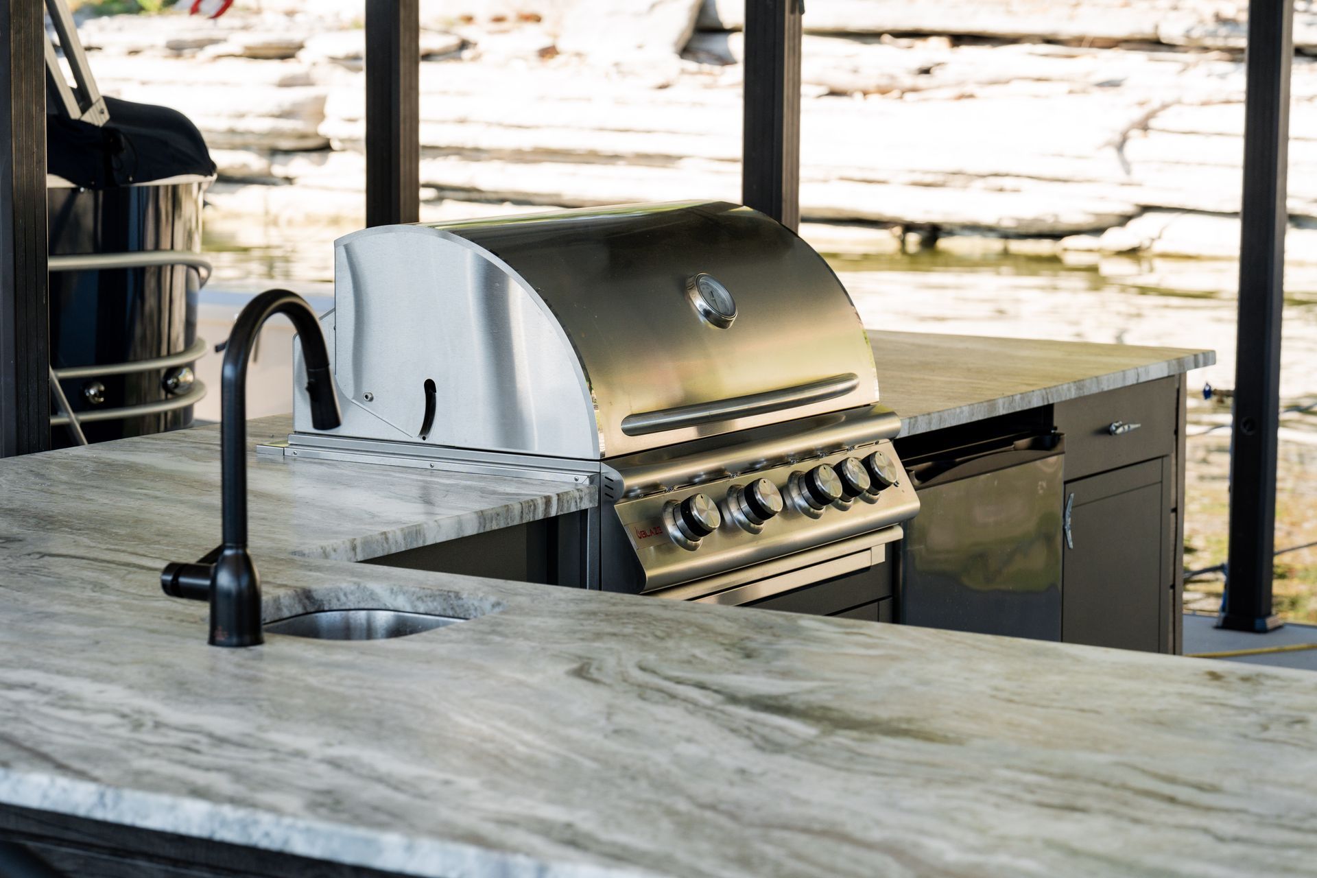 A grill is sitting on top of a counter next to a sink.