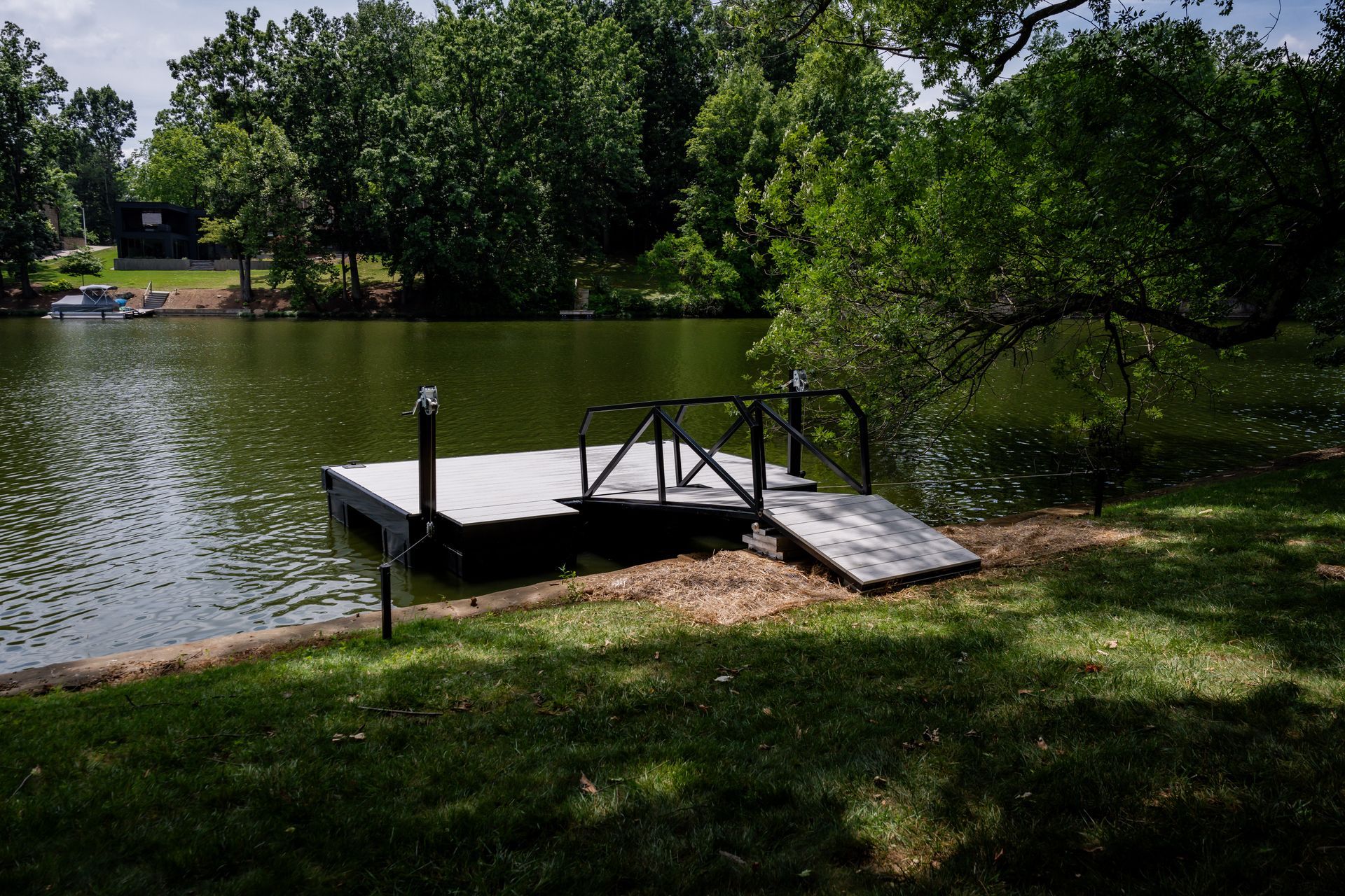 A dock is sitting on the shore of a lake surrounded by trees.