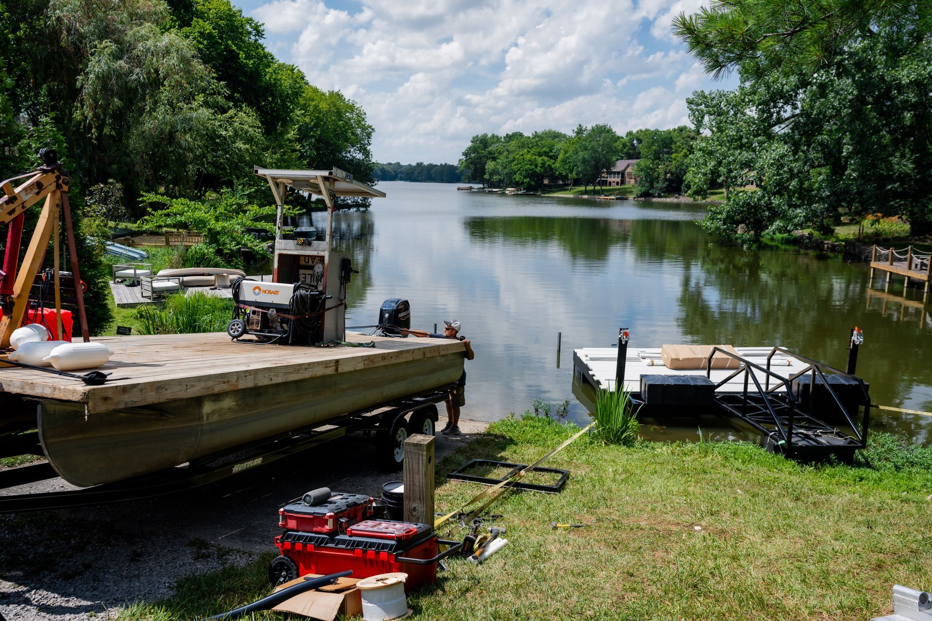 A boat is sitting on a dock next to a lake.