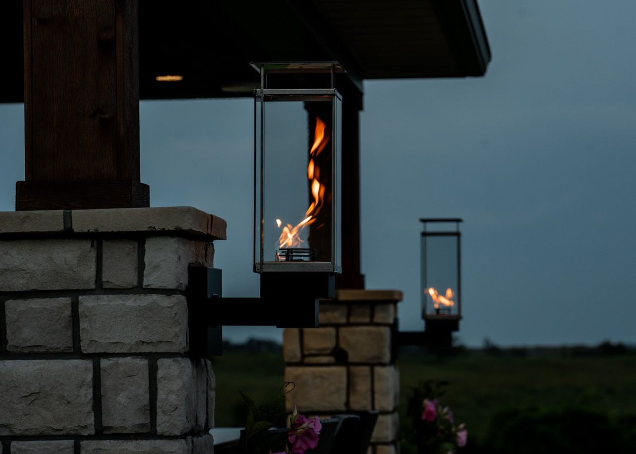 A lantern with a fire inside of it is lit up at night.