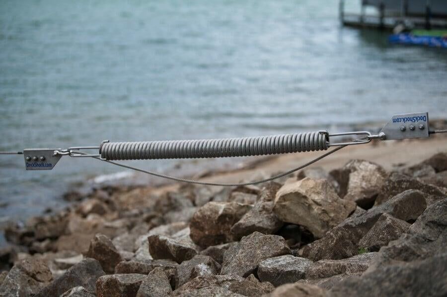 Metal Spring Is Sitting on Top of A Pile of Rocks Next to A Body of Water - Dock Solutions of Kentucky | Lexington, KY