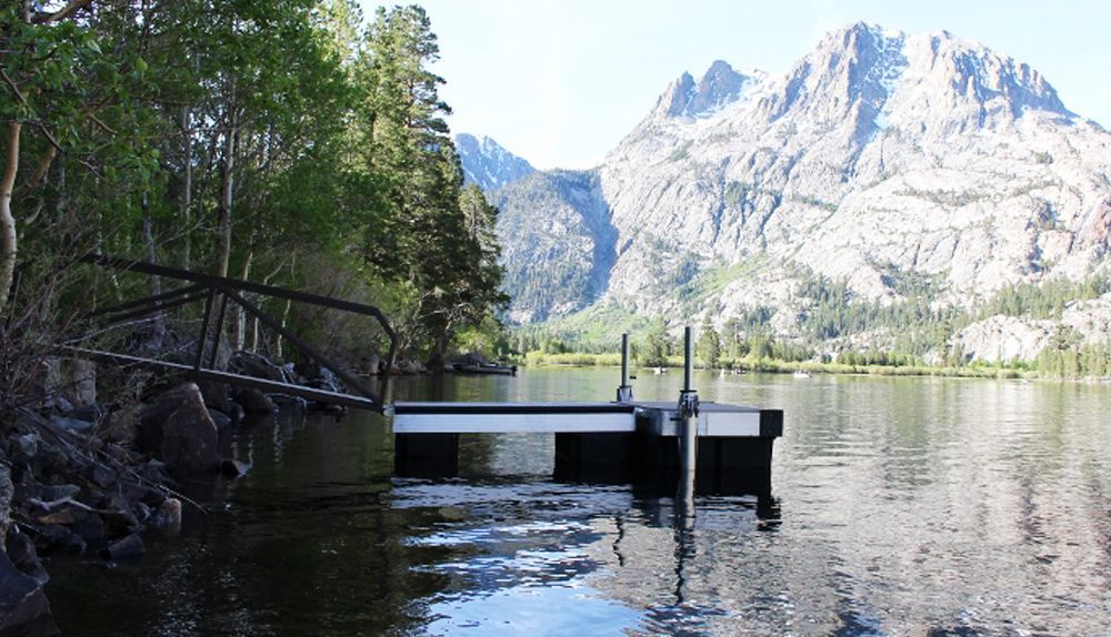A dock in the middle of a lake with mountains in the background - Dock Solutions of Kentucky | Lexington, KY