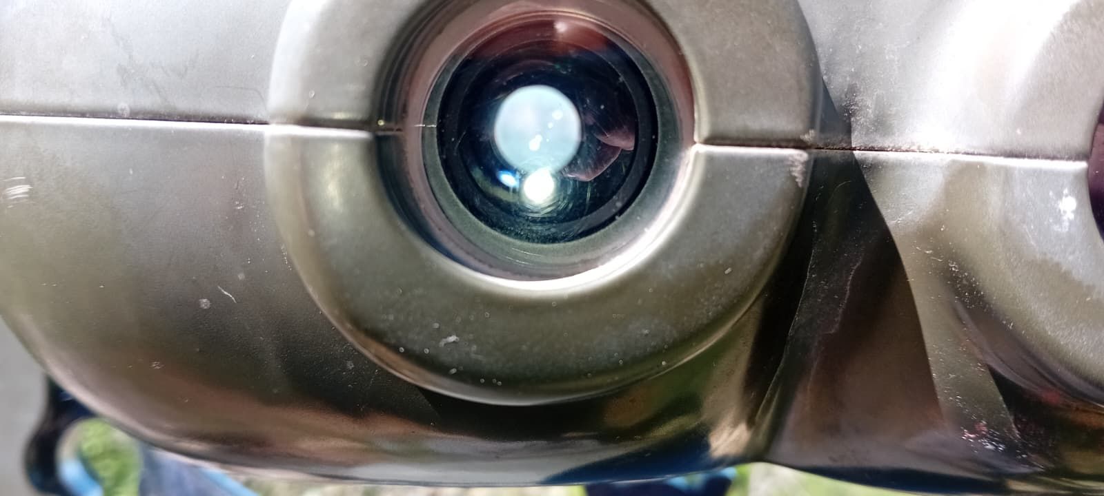 Close-up of a metallic robot face with a glowing camera lens eye