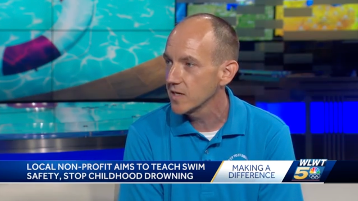 A man in a blue shirt is on a news channel