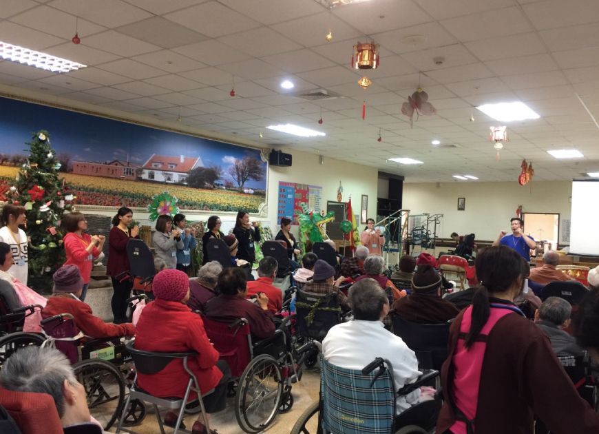 聖力團隊與坐輪椅長輩在裝飾房間參加團體關懷活動,落實人性化照護與社會關懷精神。