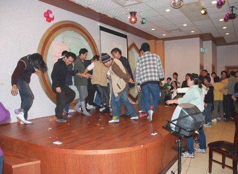 聖力國際舉辦的外籍勞工節慶聯誼活動,移工在裝飾燈光與氣球的舞台上愉快跳舞休息。