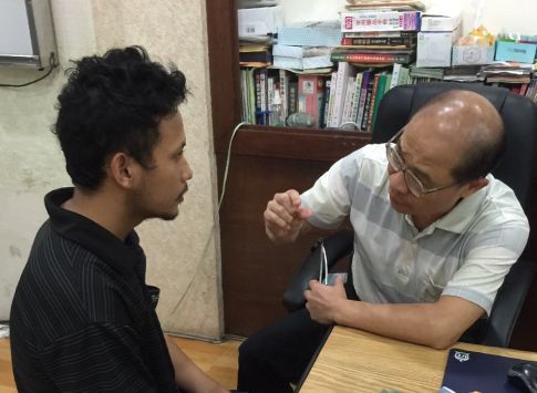 外籍移工與聖力專業輔導員或翻譯在辦公室進行面對面諮詢,提供生活與工作上的溝通協助。