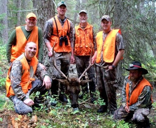 A group of hunters posing for a picture with a moose