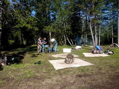 A group of people are sitting at a picnic table in a park.