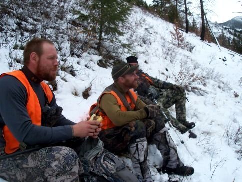 A group of hunters are sitting in the snow