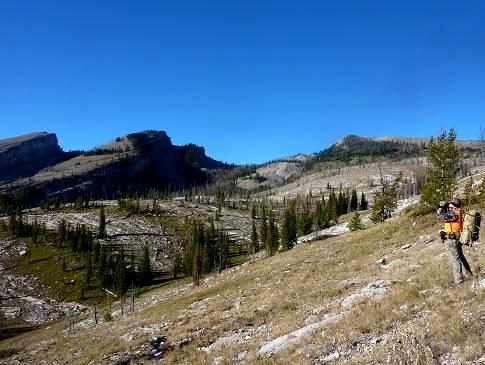 A person is walking up a hill in the mountains.