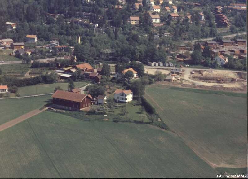 Vi ser Nordre Levre gård i forgrunnen. Bærumsveien går diagonalt gjennom bildet i bakgrunnen. Trolig var Parykk-myra ved 