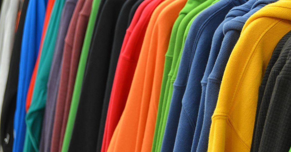 A row of colorful sweatshirts hanging on a rack