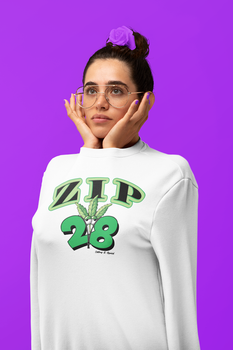 A woman wearing glasses and a white sweatshirt is standing in front of a purple background.