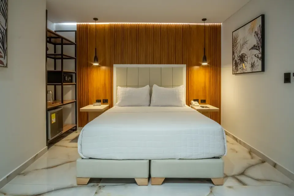 Habitación del Hotel 111 en San Andrés con cama iluminada en luz tenue, ideal para parejas en escapada romántica cerca a la playa.