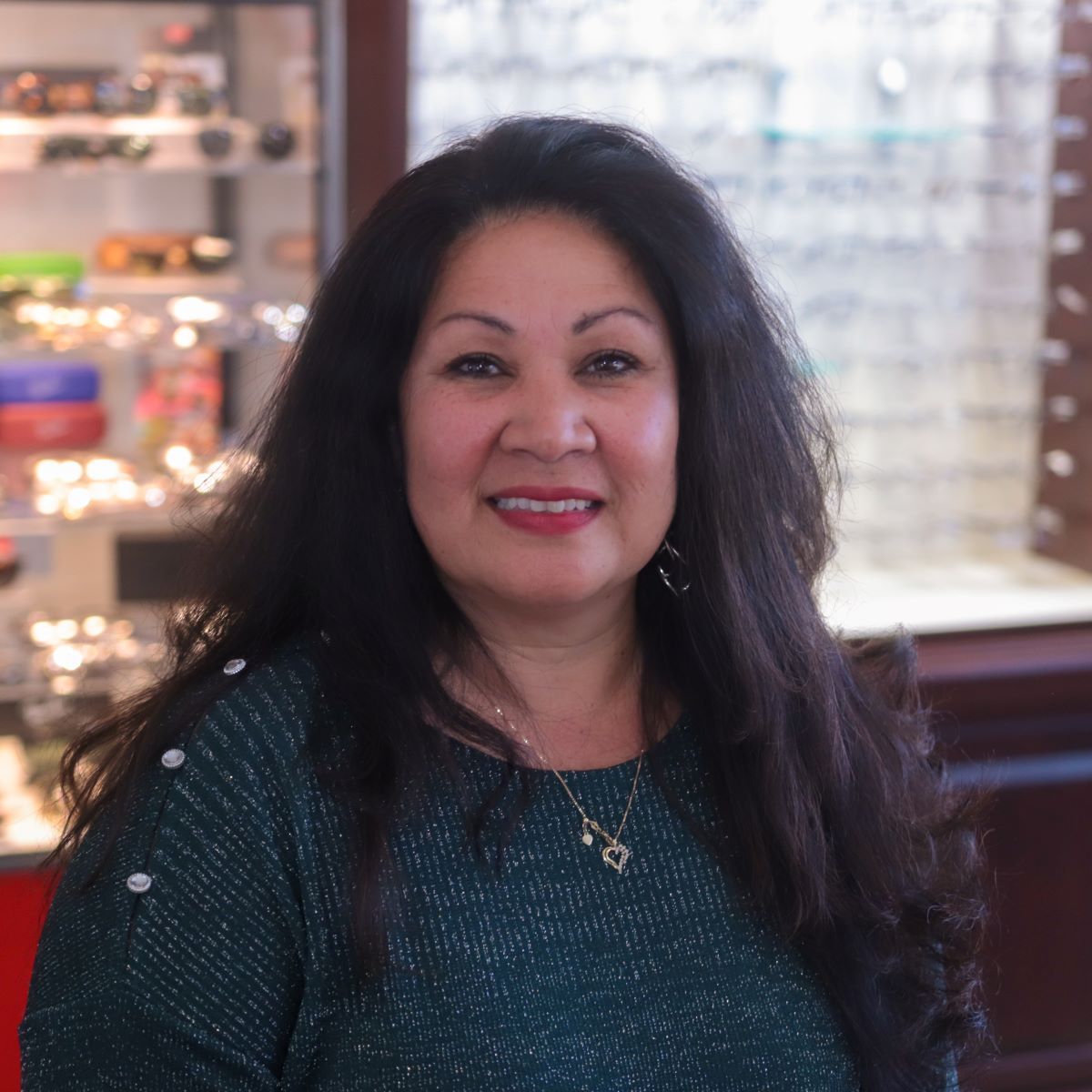 A woman wearing a green sweater is smiling for the camera