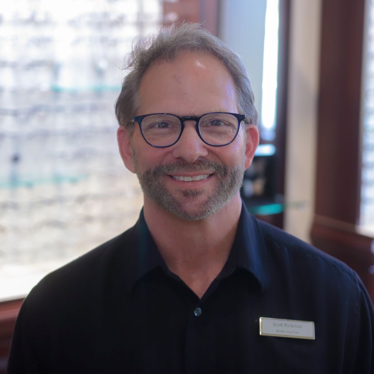 A man with glasses and a beard is smiling for the camera.