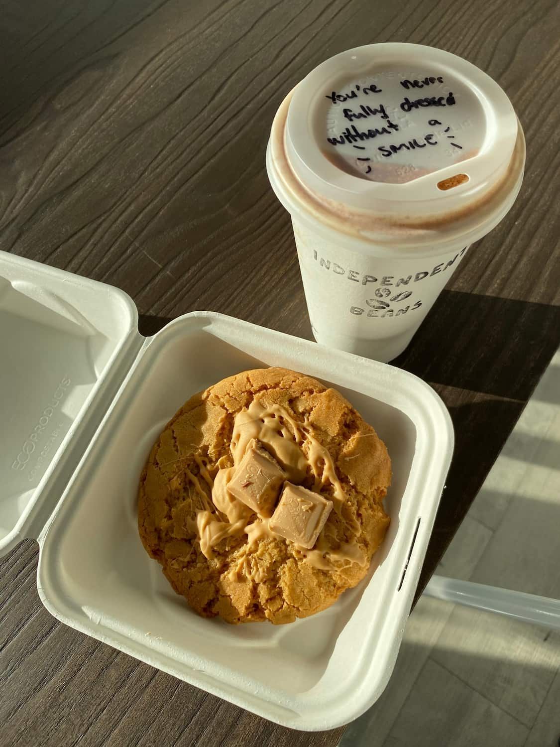 A Cup Of Coffee And A Cookie In A Styrofoam Container On A Table — Independent Beans in Kirwan, QLD