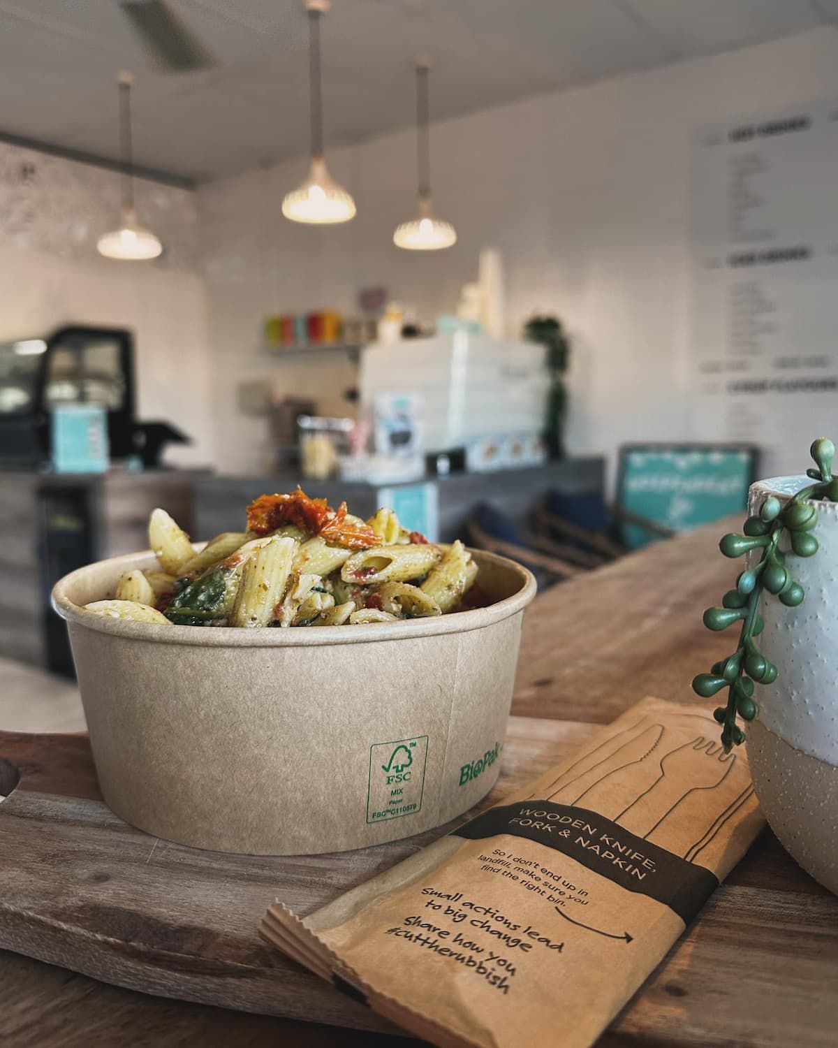 A Bowl Of Pasta Is Sitting On A Wooden Table In A Restaurant — Independent Beans in Kirwan, QLD