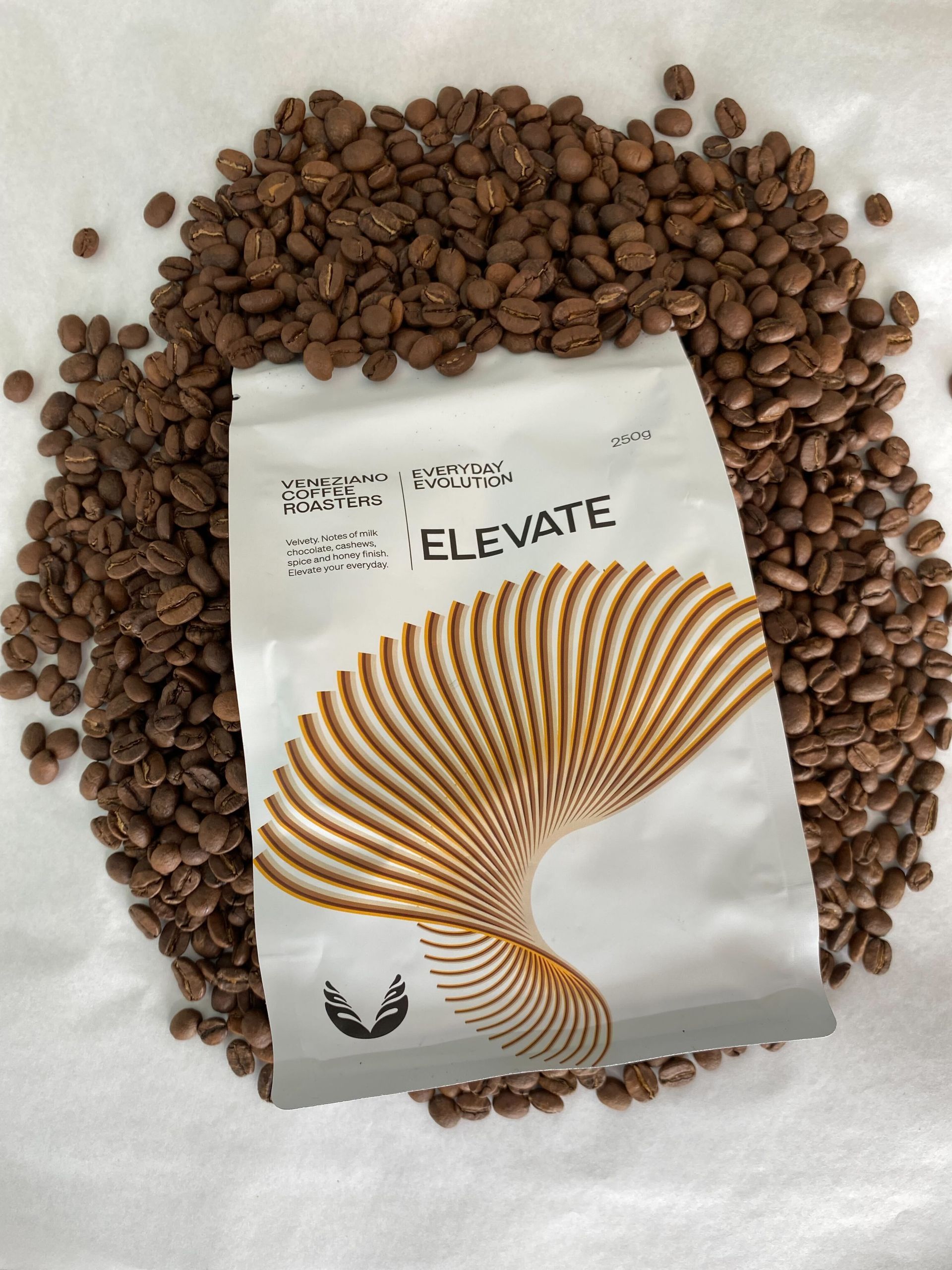 A Coffee Bag That Says Elevate On Top Of Coffee Beans — Independent Beans in Kirwan, QLD