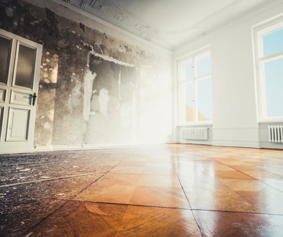 An empty room with a wooden floor and white walls.