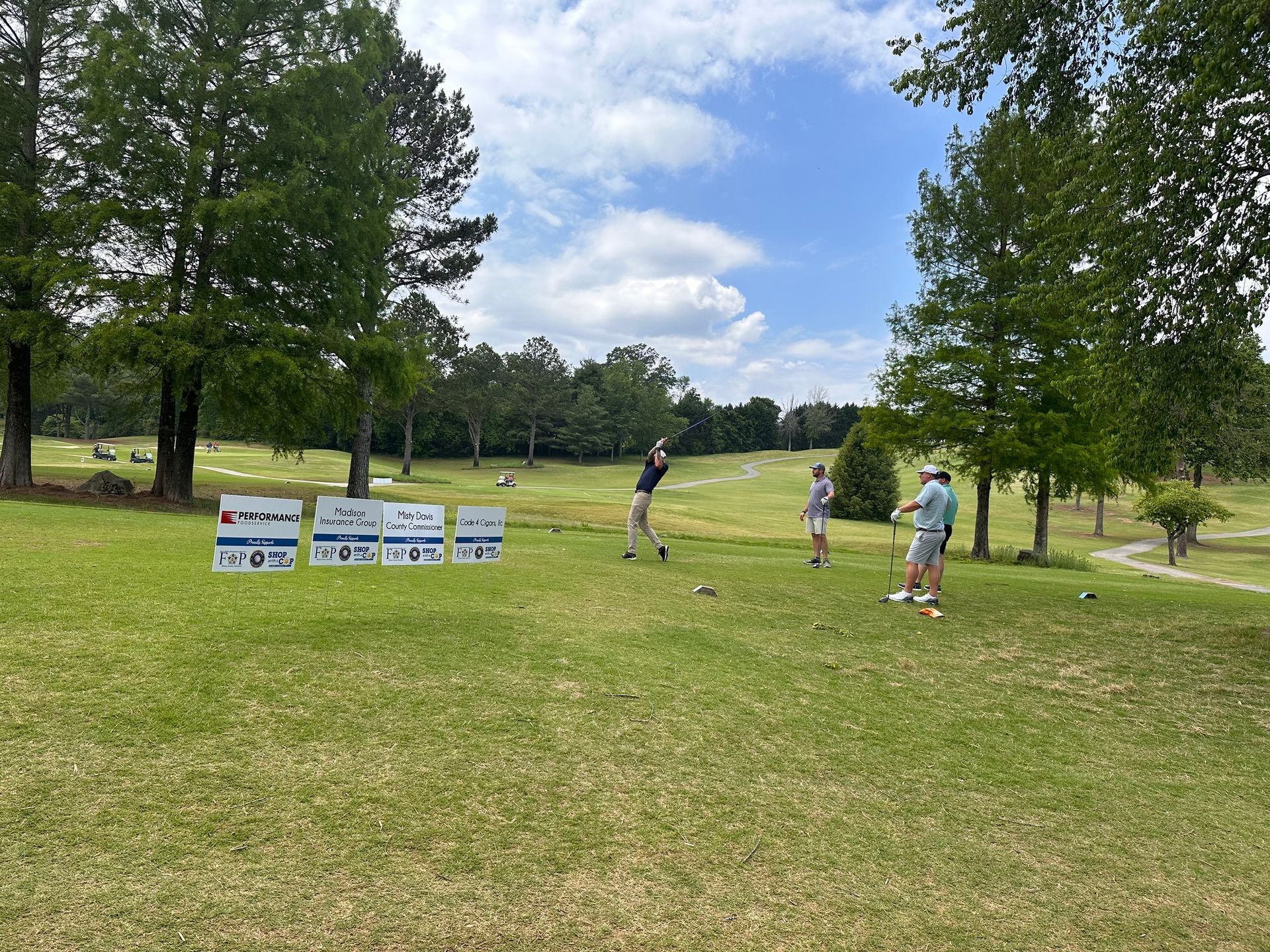 A group of people are playing golf on a golf course.