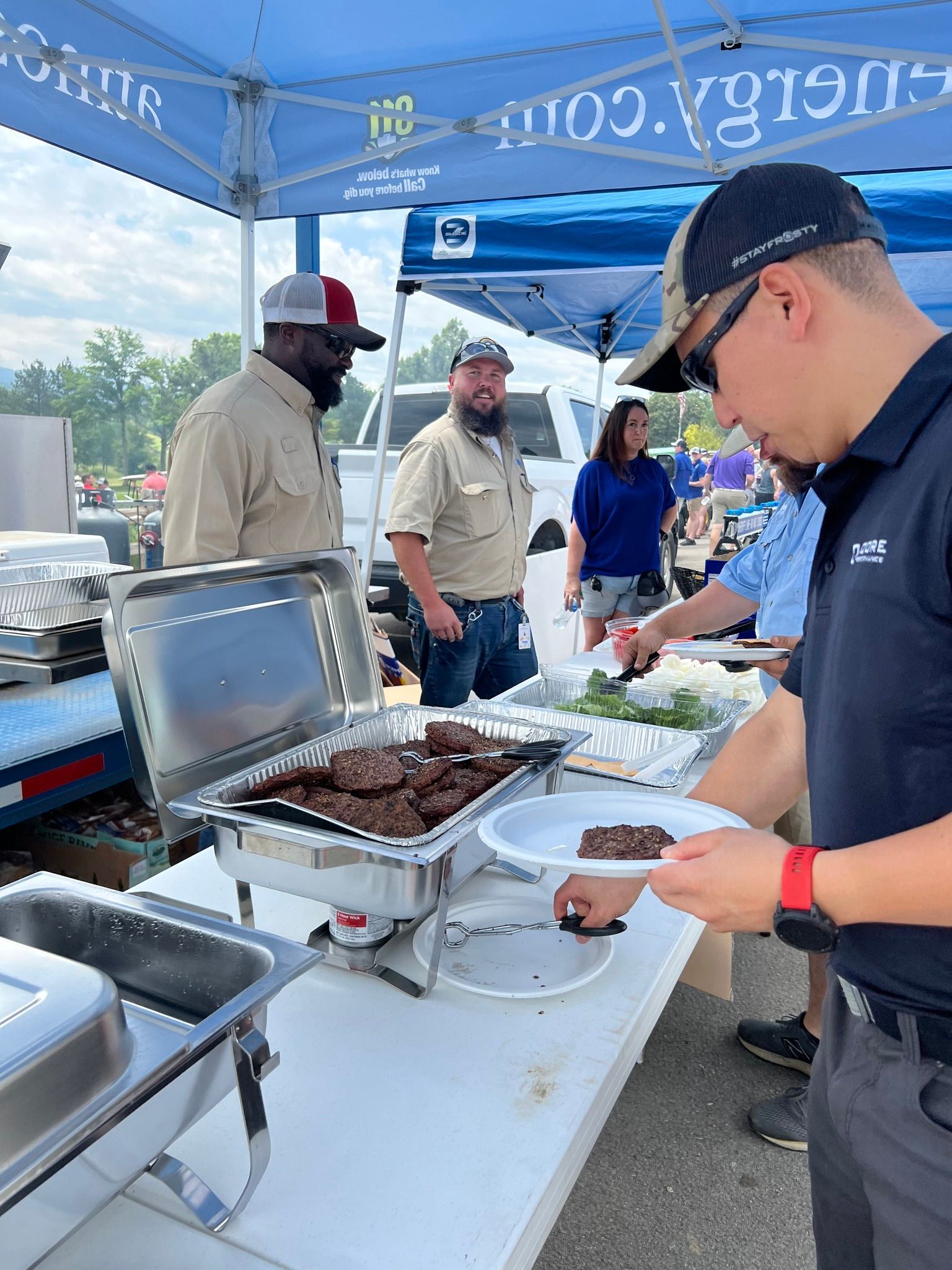 A man is taking a plate of food from a buffet table.