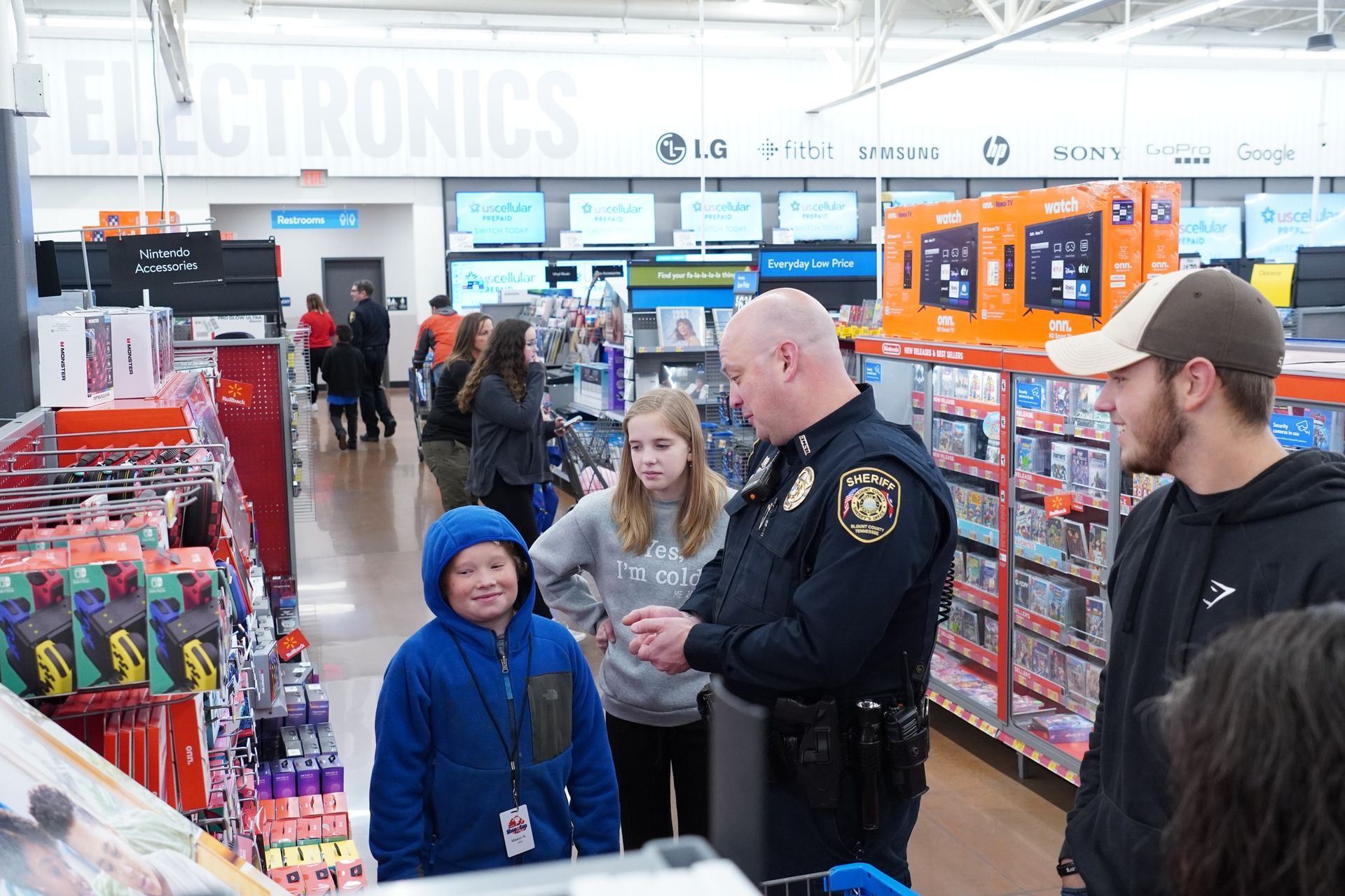 A police officer is talking to a group of people in a store.