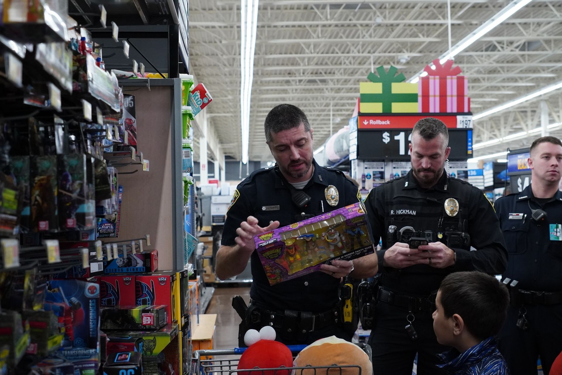 A group of police officers are looking at toys in a store.