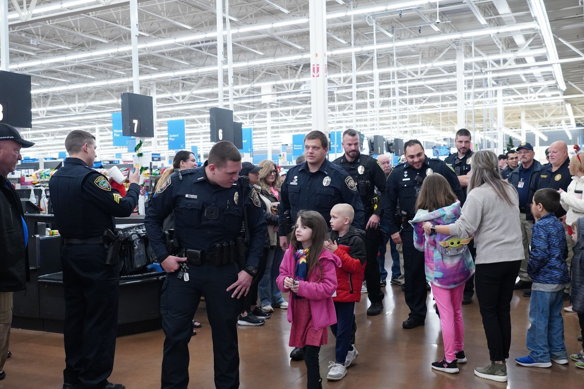 A group of people are standing in a store with police officers.