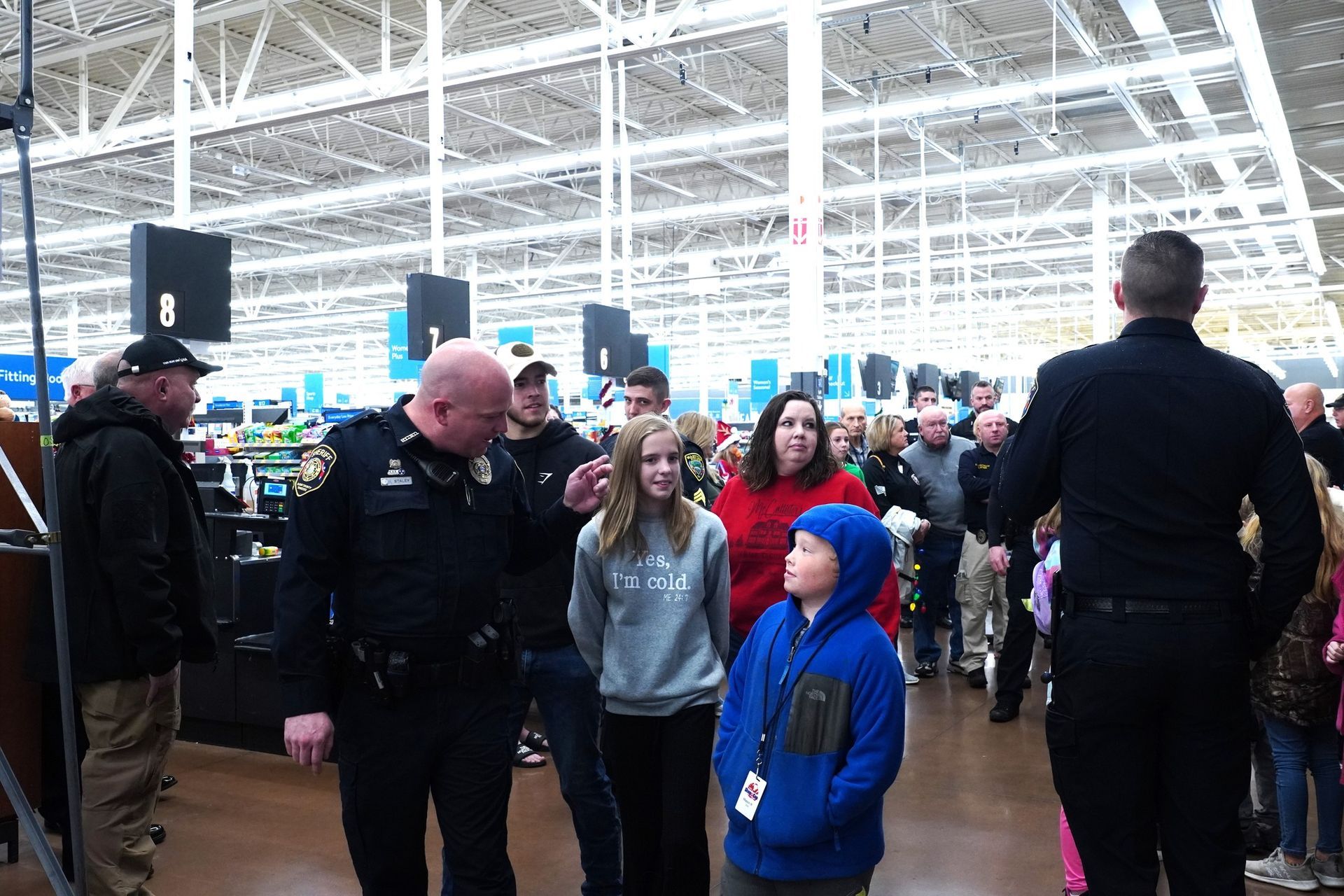 A group of police officers are talking to a group of people in a store.