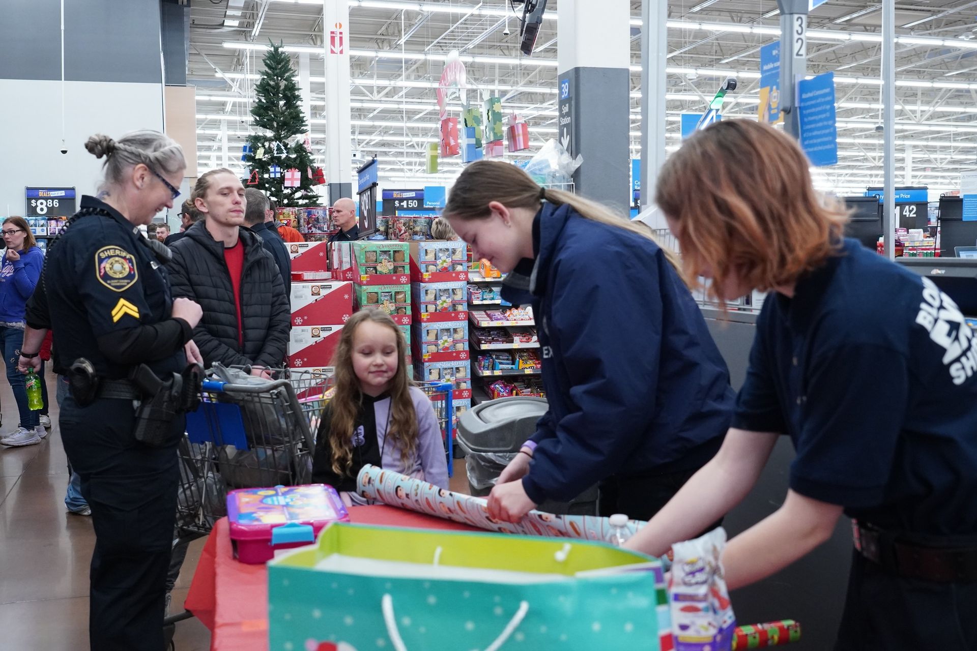 A group of people are wrapping gifts in a store.