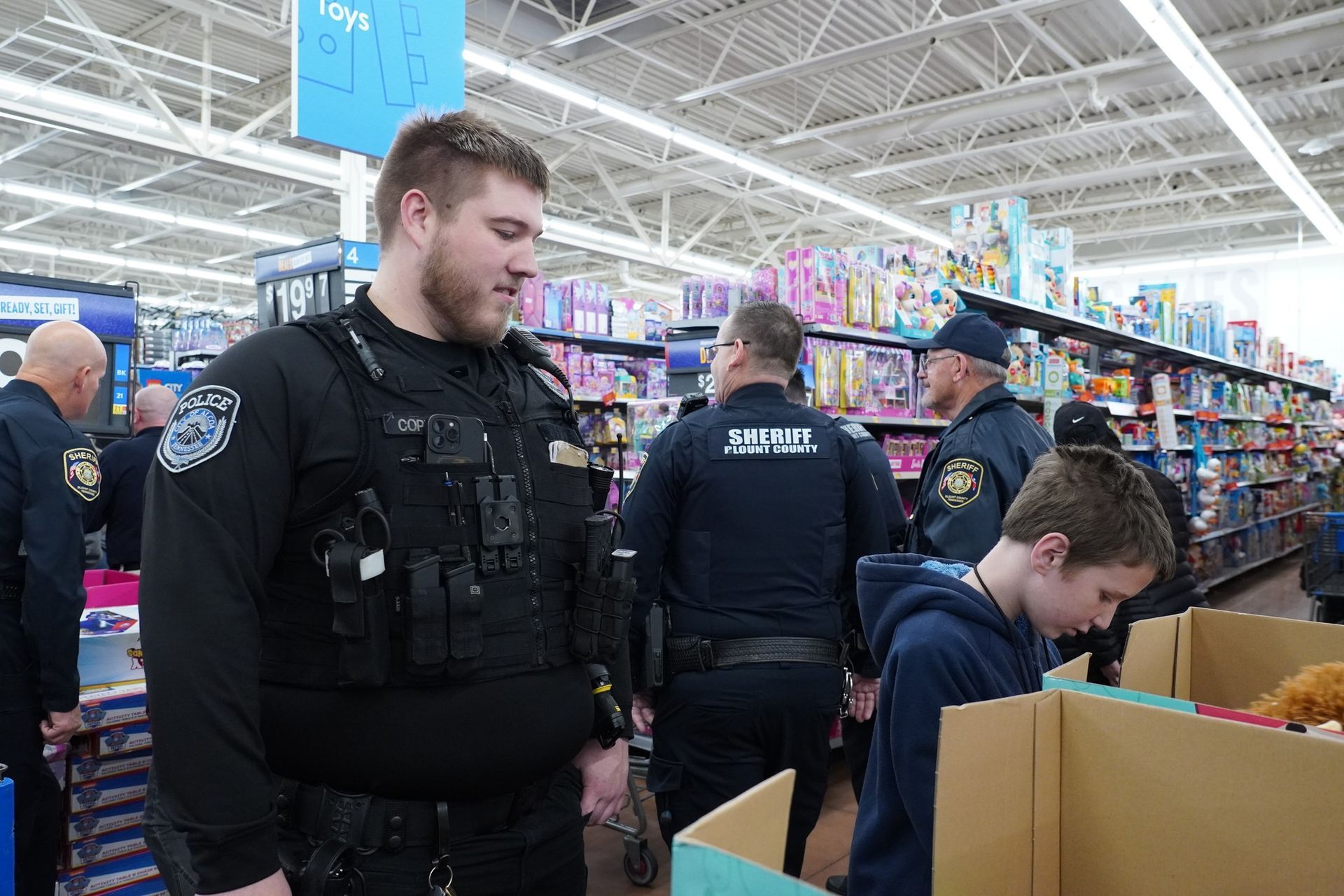 A group of police officers are standing in a toy store.