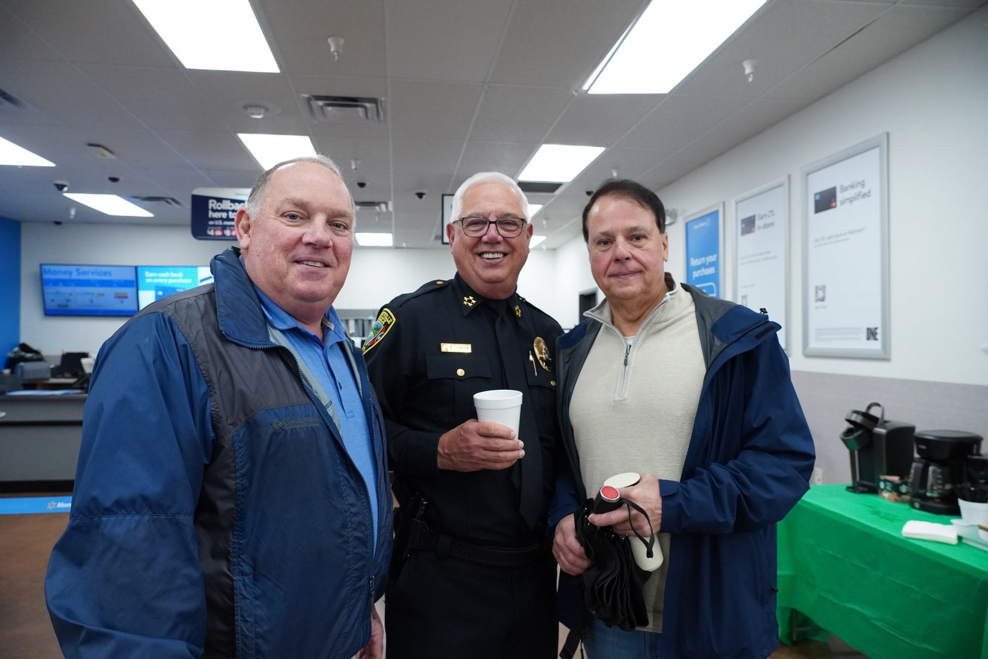 Three men are standing next to each other in a room.