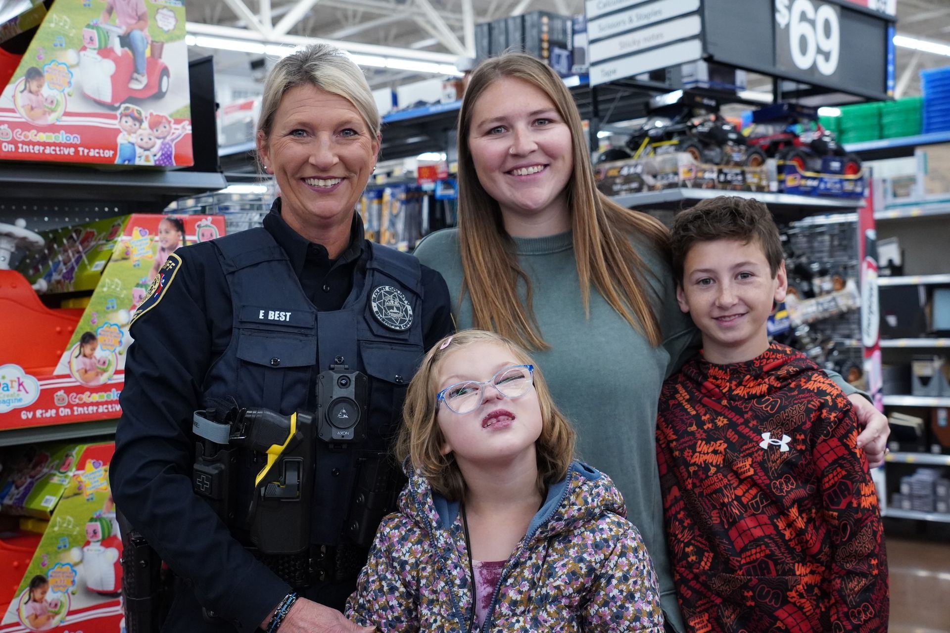 A police officer is posing for a picture with a family in a store.