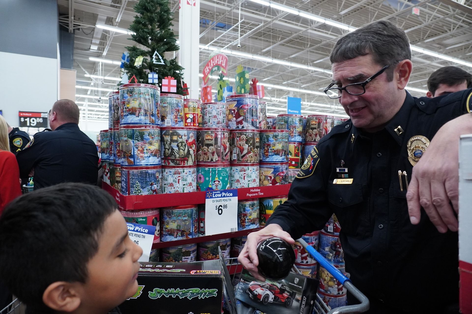 A police officer is talking to a young boy in a store.