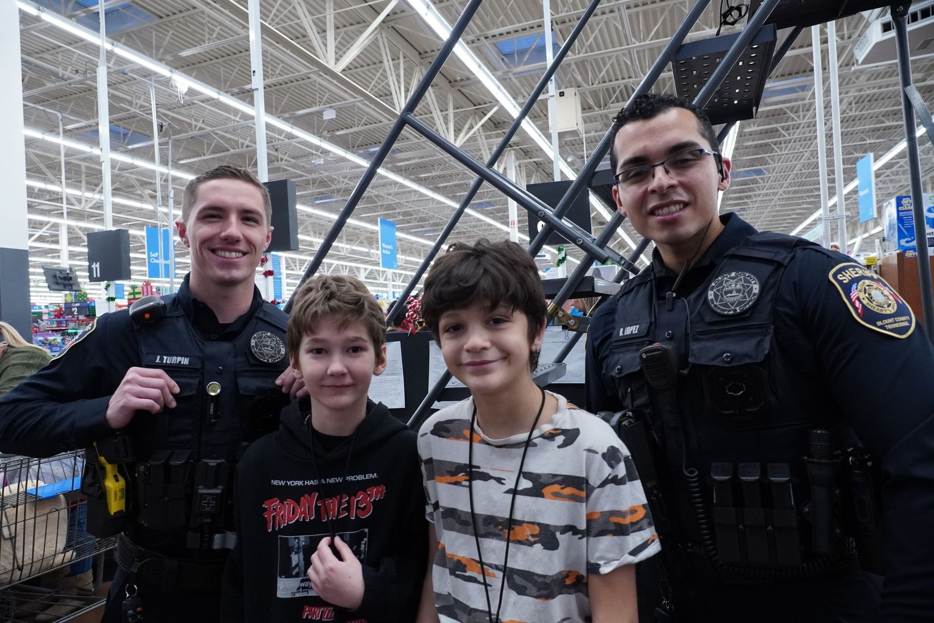 A group of police officers and two young boys are posing for a picture in a store.