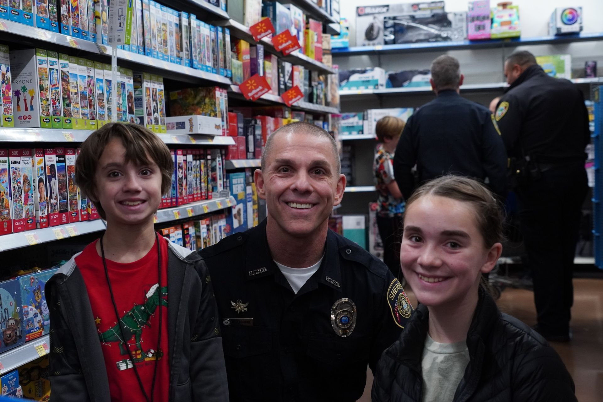 A police officer is posing for a picture with two children in a store.