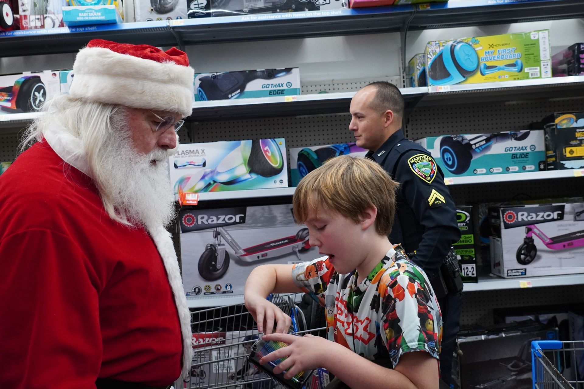 Santa claus is talking to a young boy in a store.
