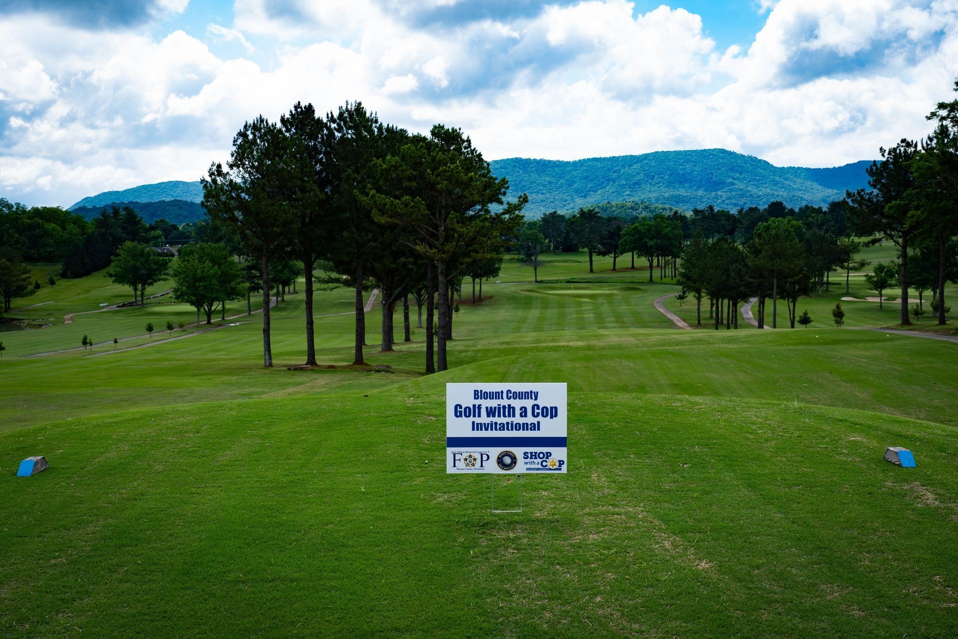 A golf course with trees and mountains in the background