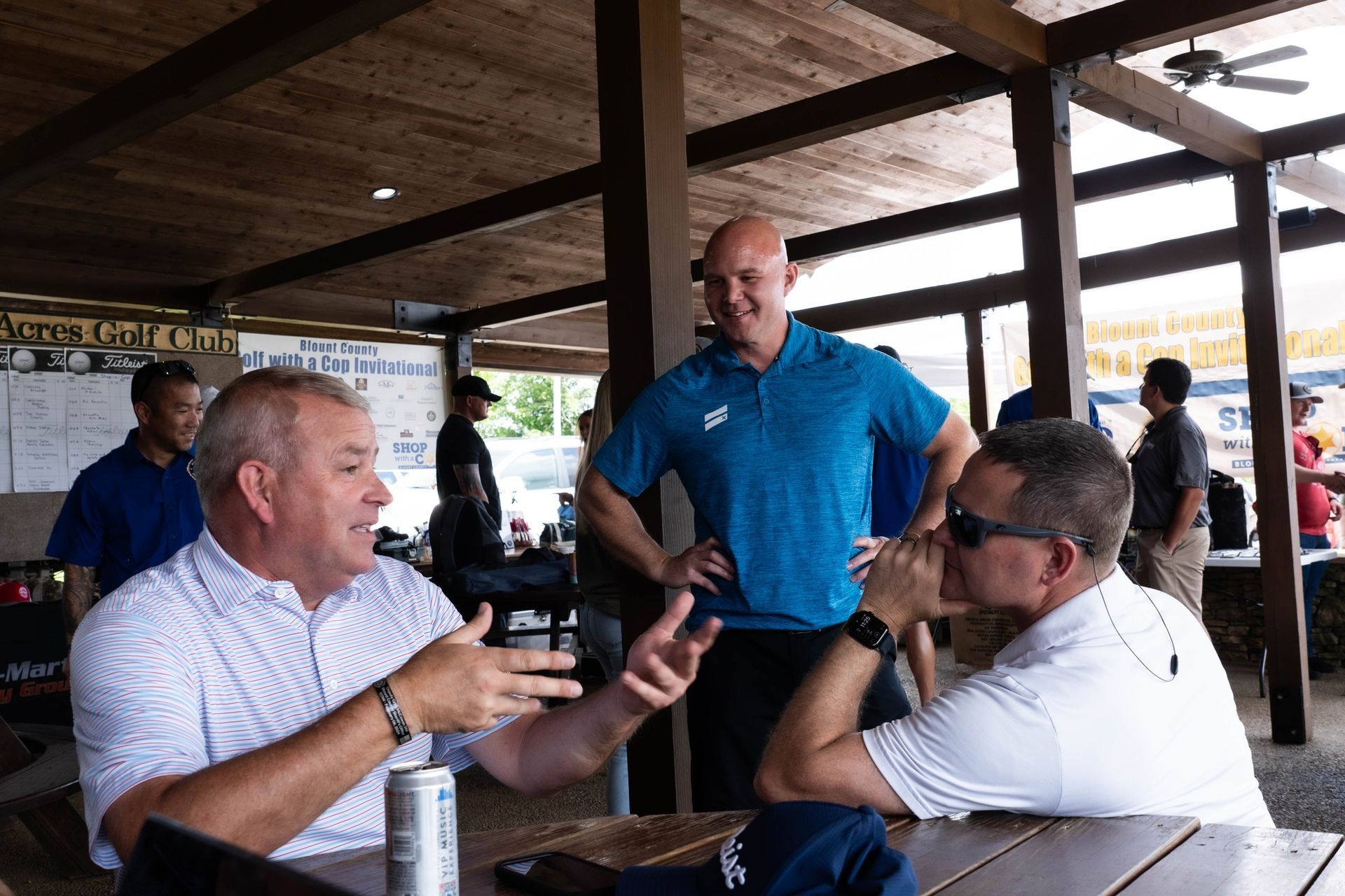 A group of men are sitting at a table talking to each other.